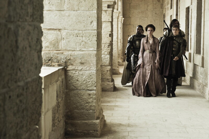 Group walking in stone corridor