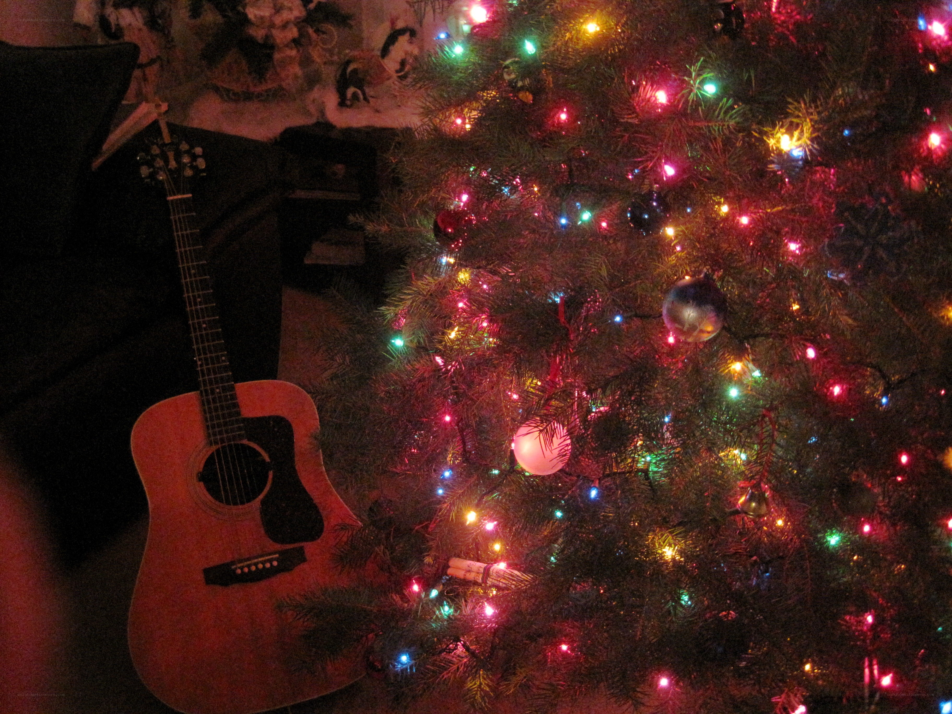 Guitar beside Christmas tree