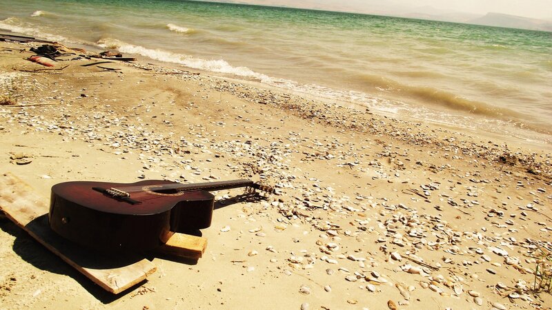 Guitar on a seashell beach