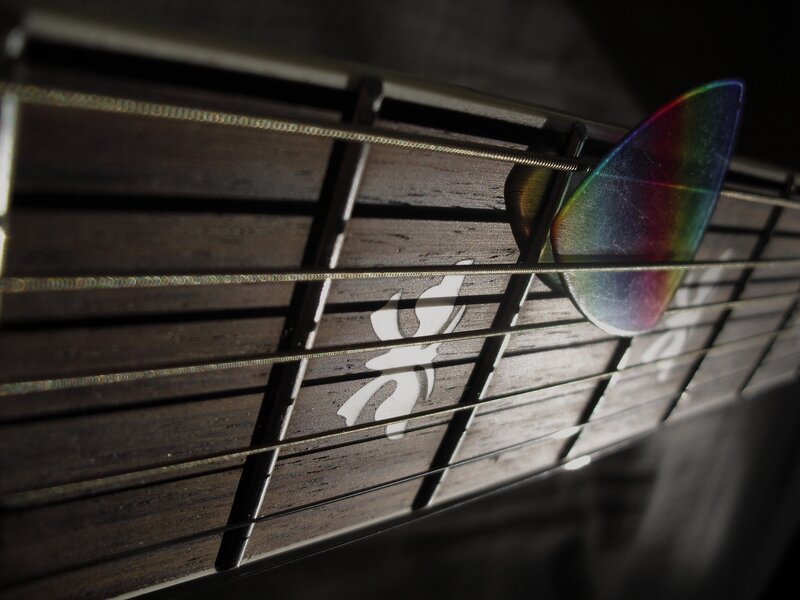 guitar pick on fretboard