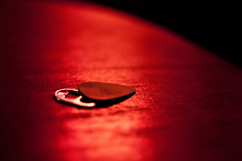 guitar pick on red surface