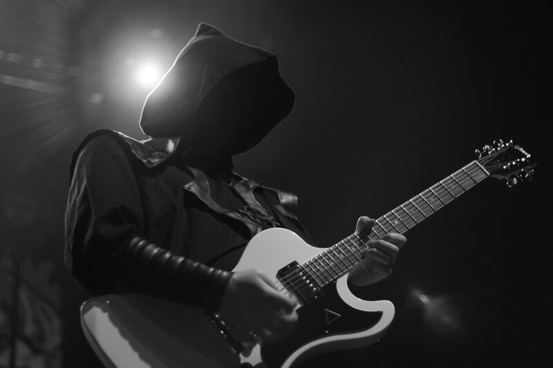 guitarist on stage in hood
