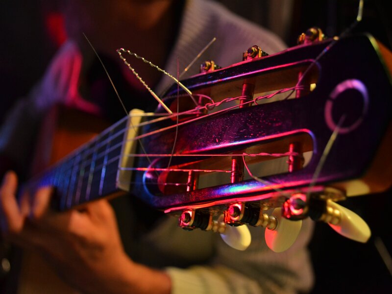 guitarist playing under colorful lights