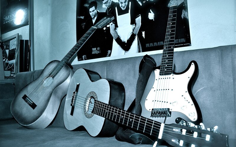 Guitars on a couch with band poster