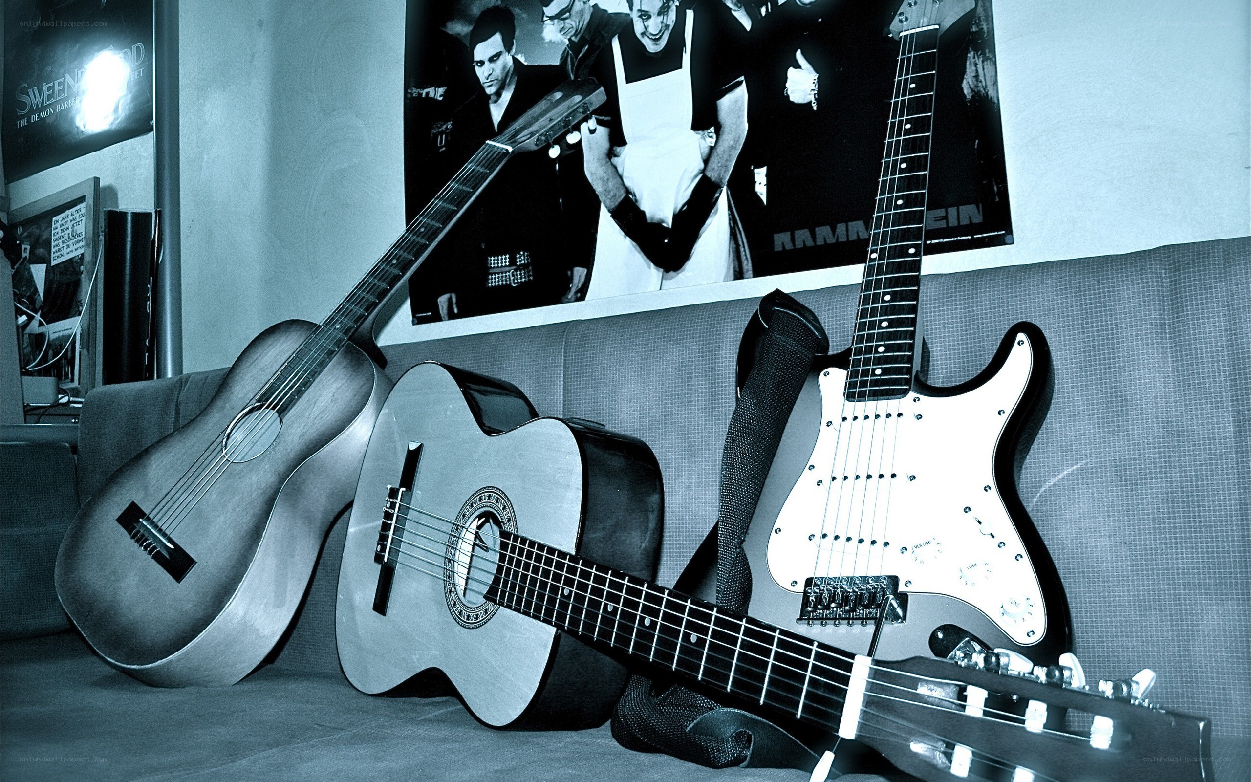 Guitars on a couch with band poster