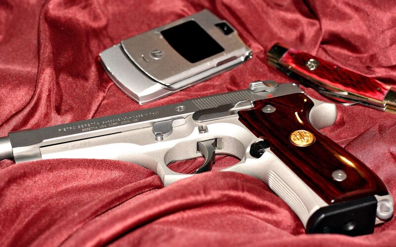 gun and phone on red cloth
