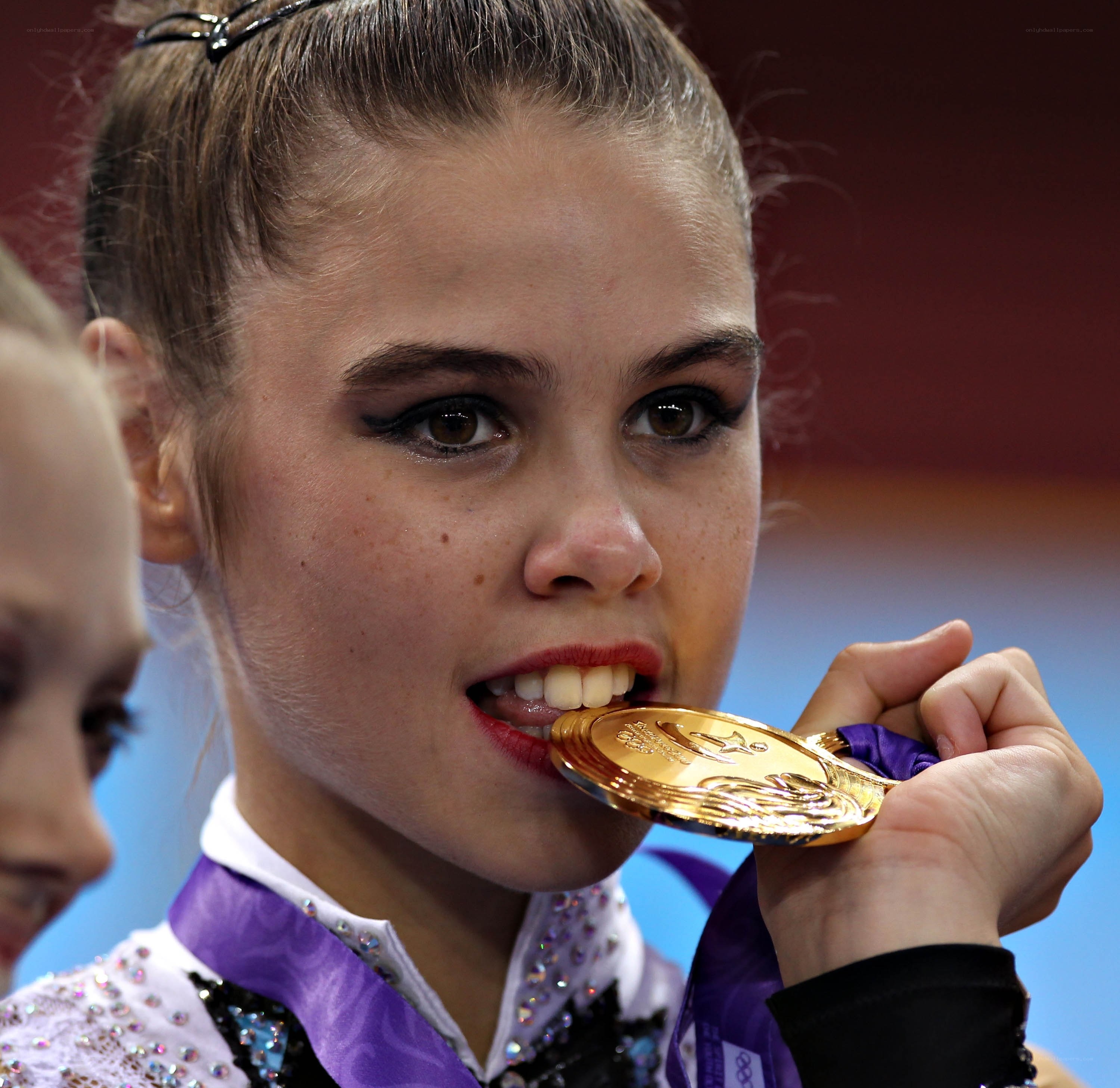 gymnast biting gold medal