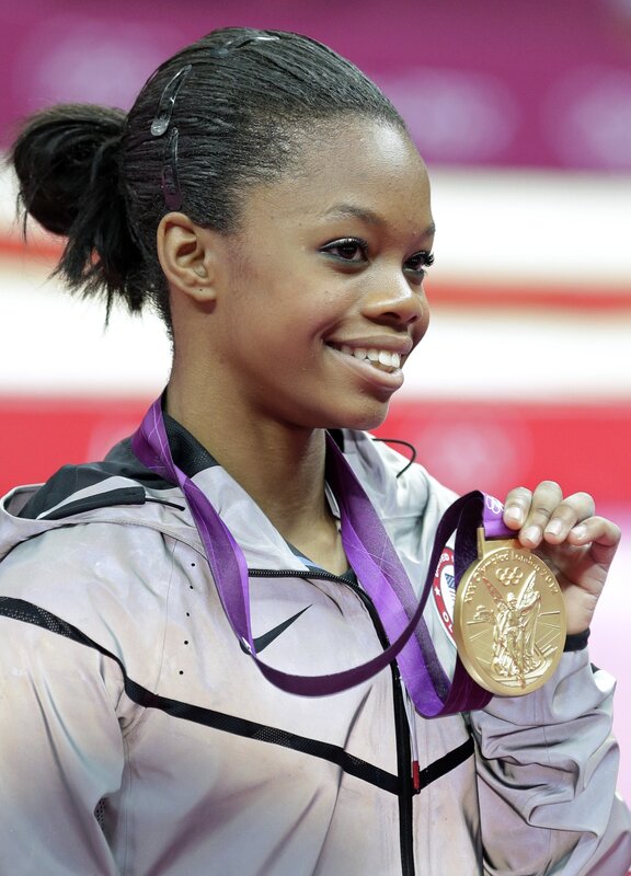 gymnast holding gold medal