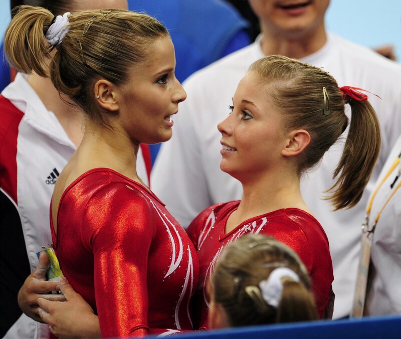 Gymnasts in red leotards