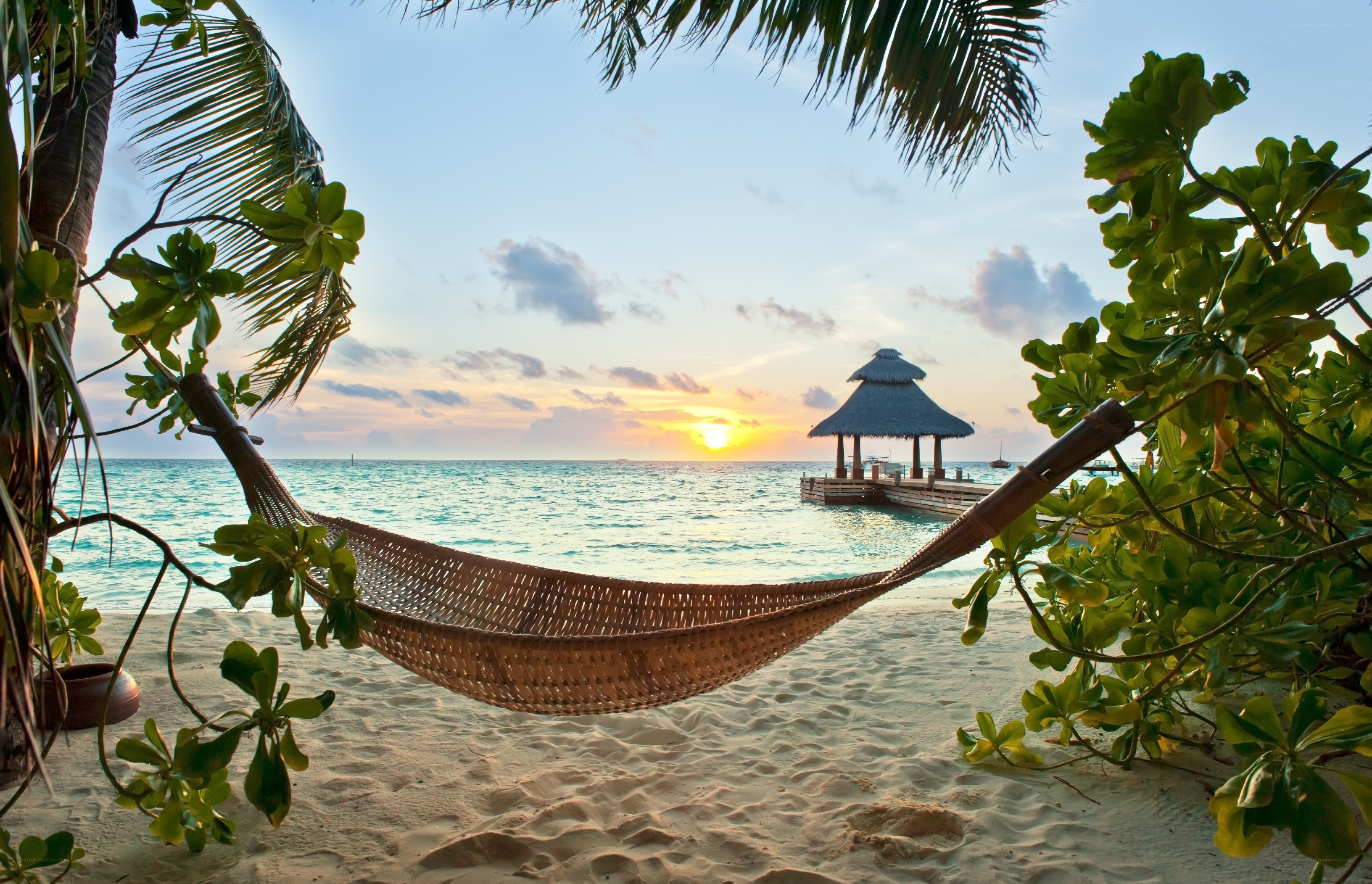 Hammock on tropical beach at sunset