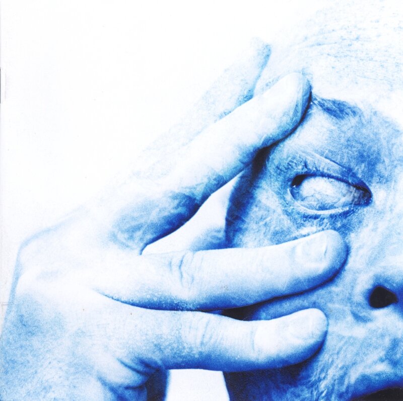 hand covering eye in blue monochrome