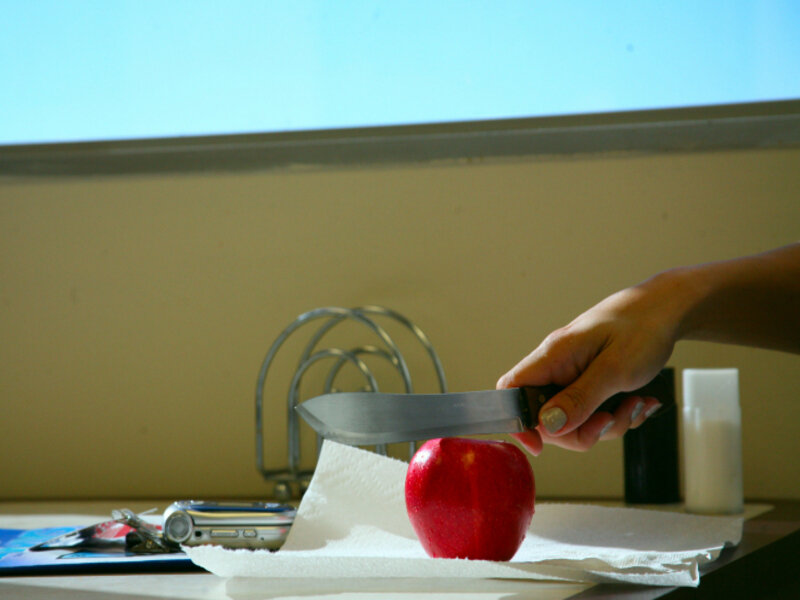 hand cutting apple with knife