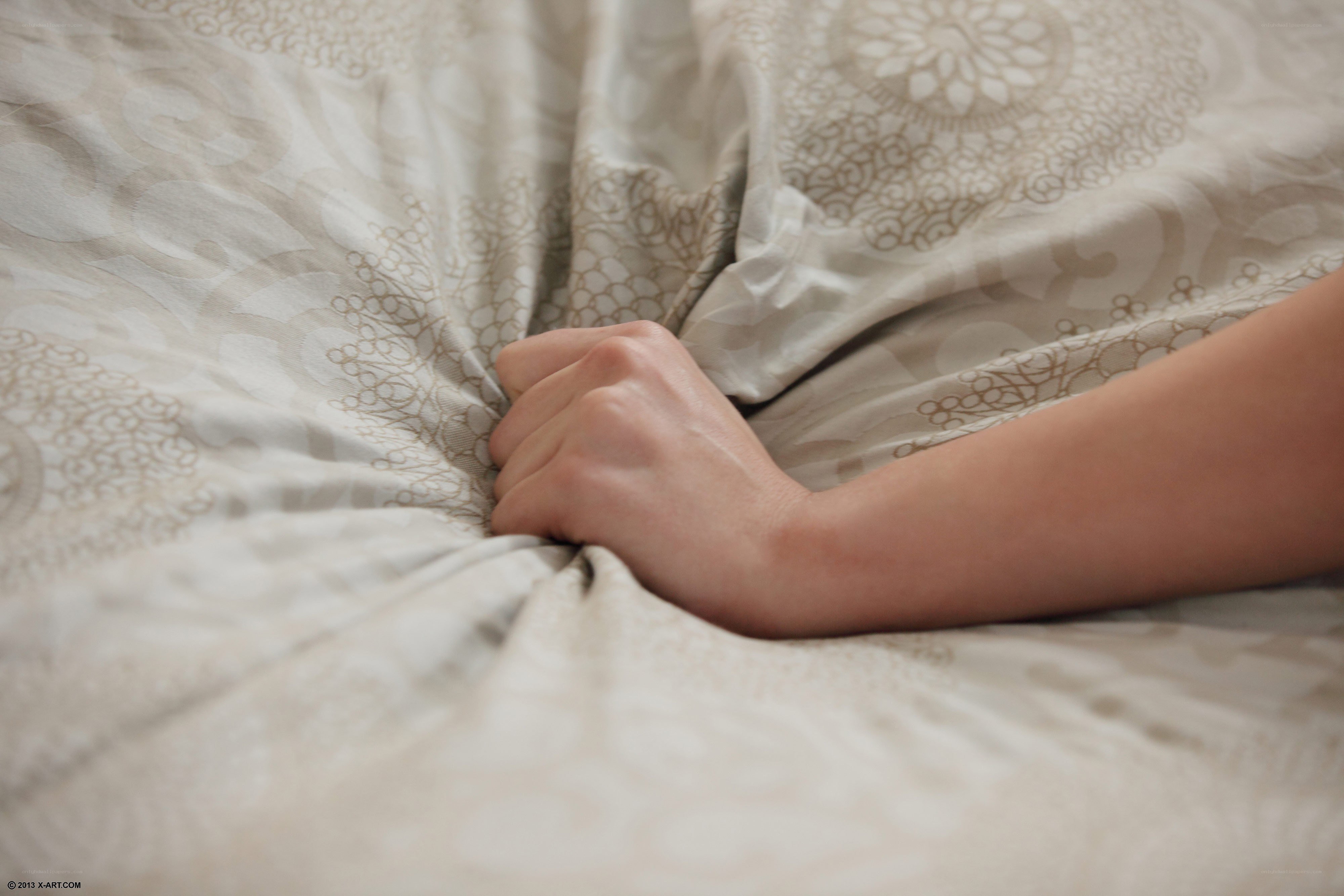 hand gripping bedsheet