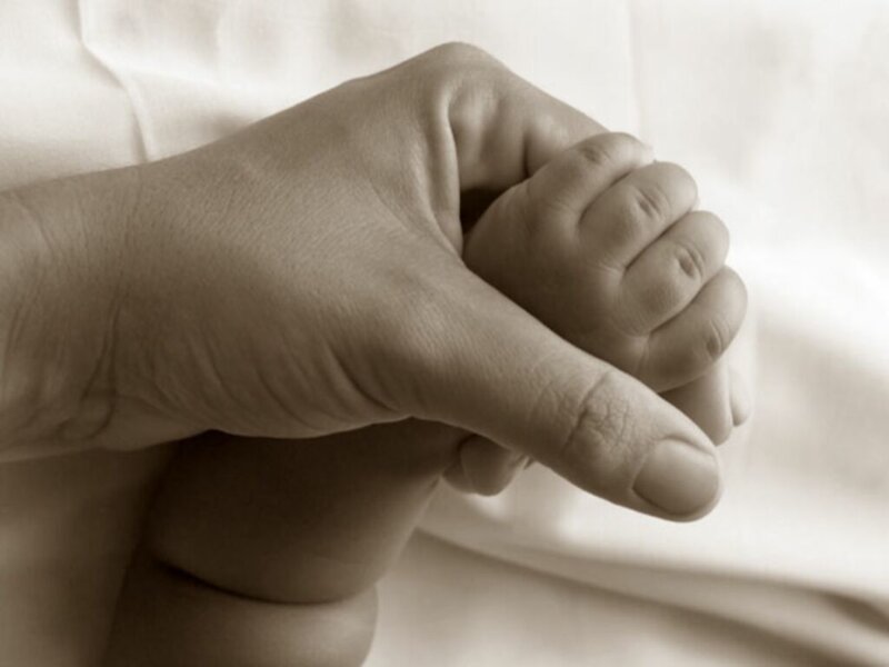 Hand holding a baby's foot