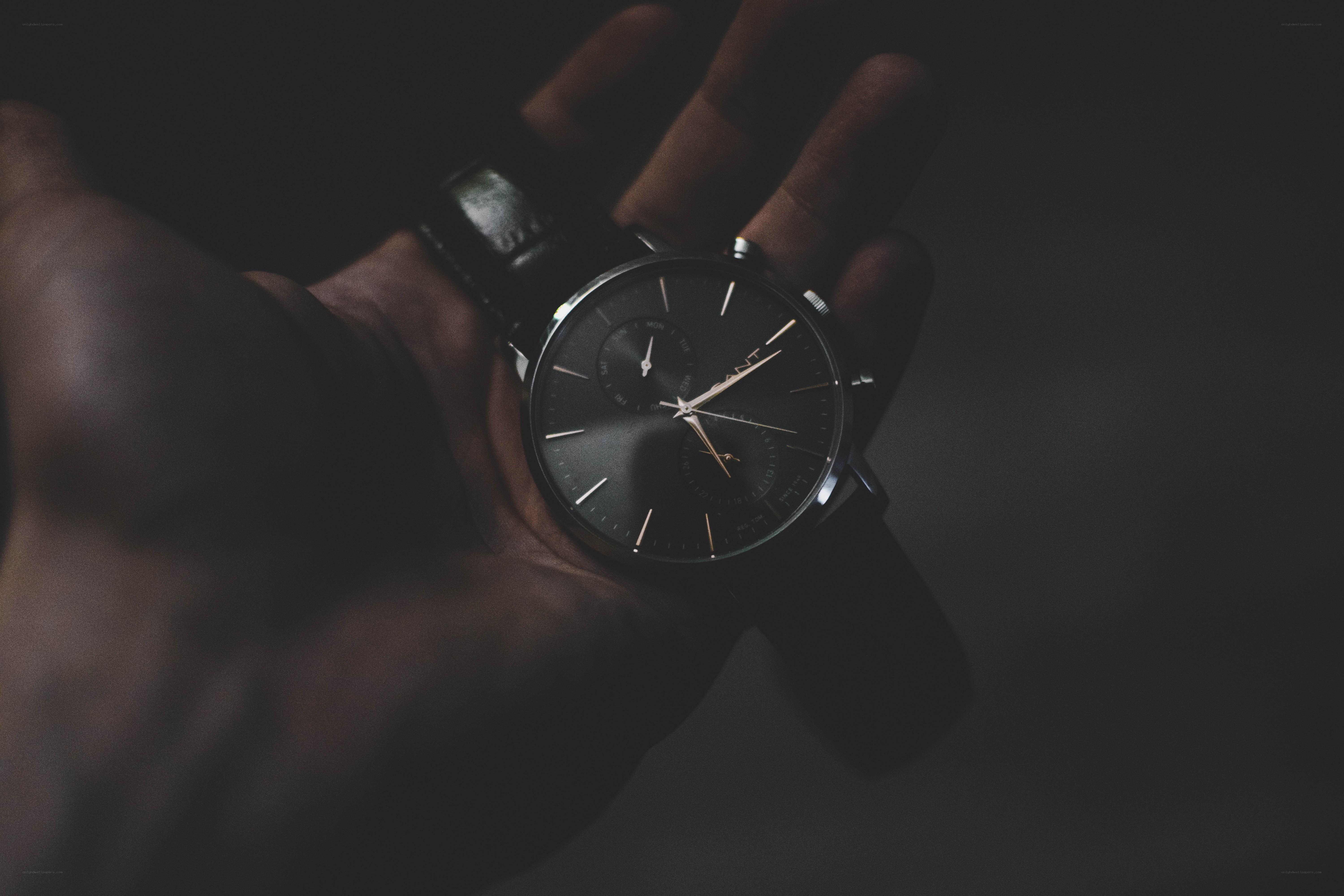 hand holding a black watch