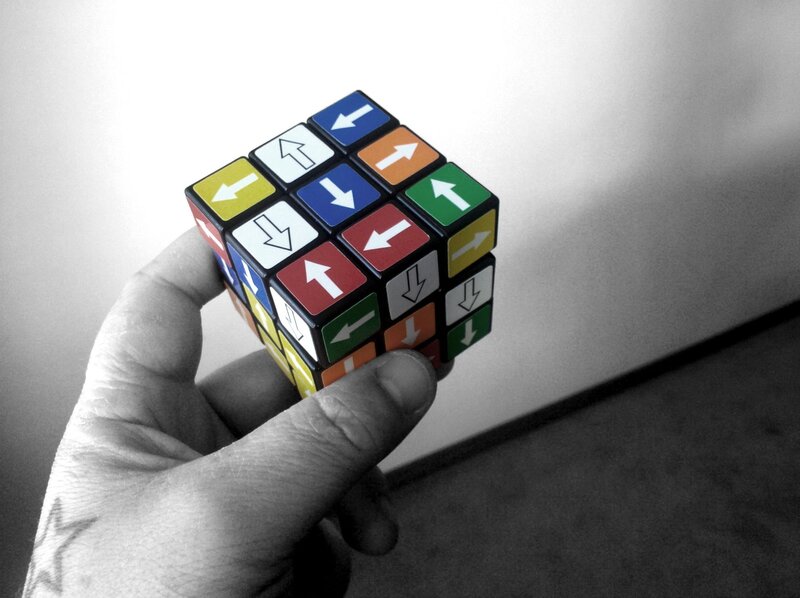 hand holding a directional rubik's cube