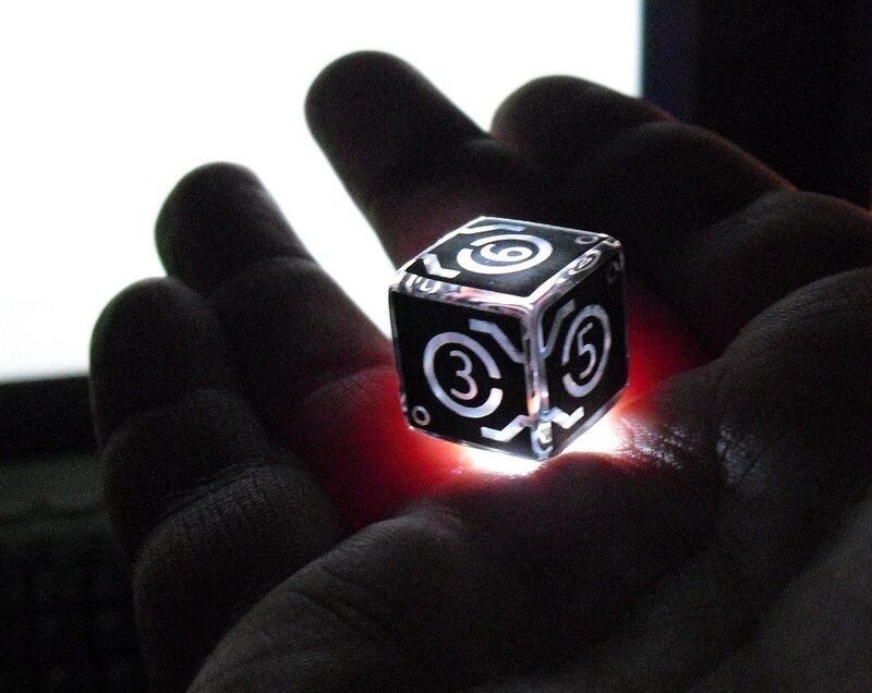 Hand holding a glowing die