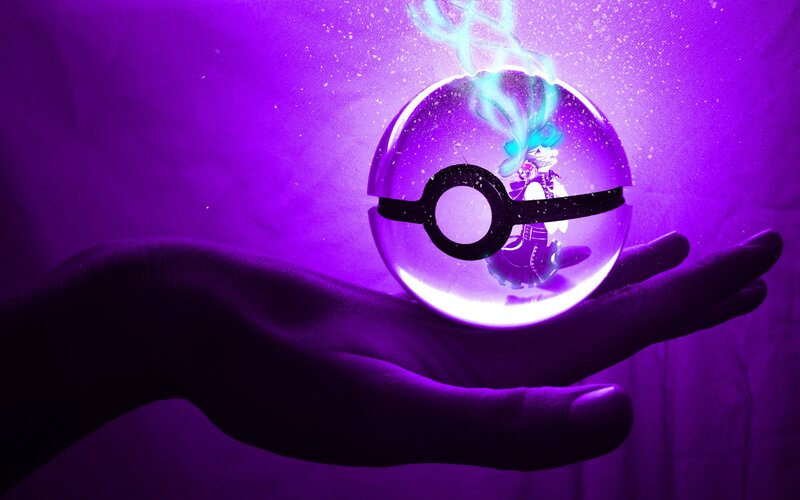hand holding a glowing pokeball