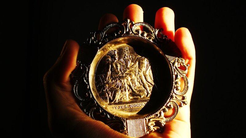 Hand holding a golden medallion