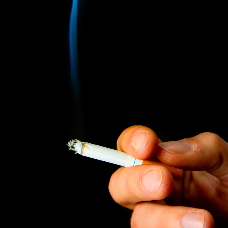 hand holding a lit cigarette