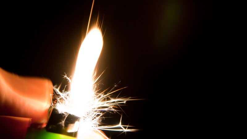 hand holding a lit lighter