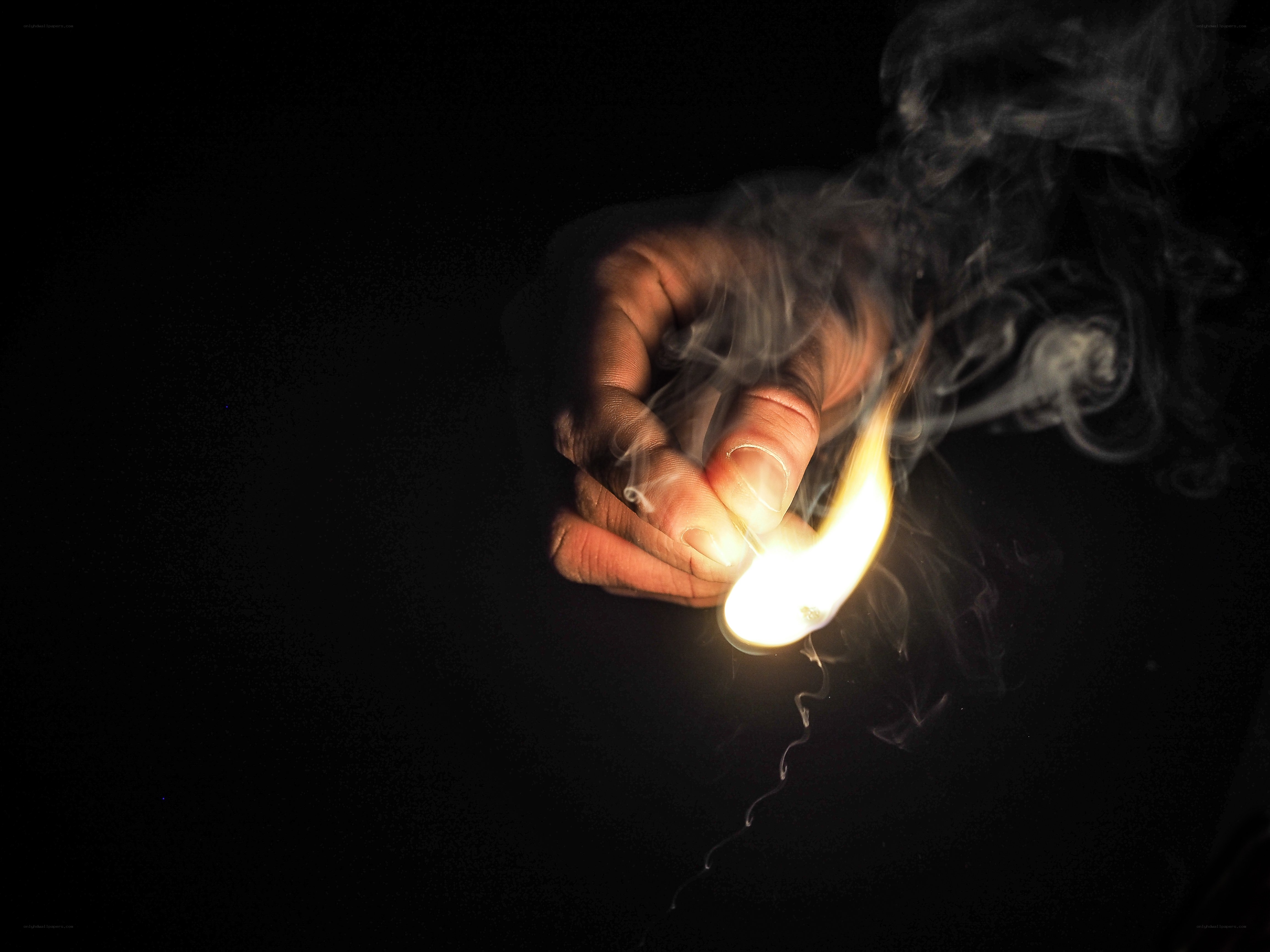 hand holding a lit match