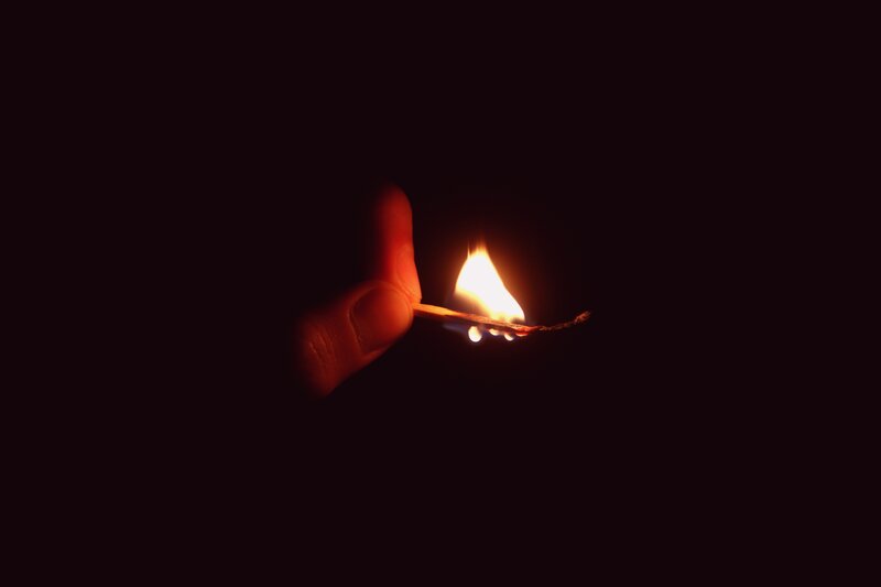 hand holding a lit match
