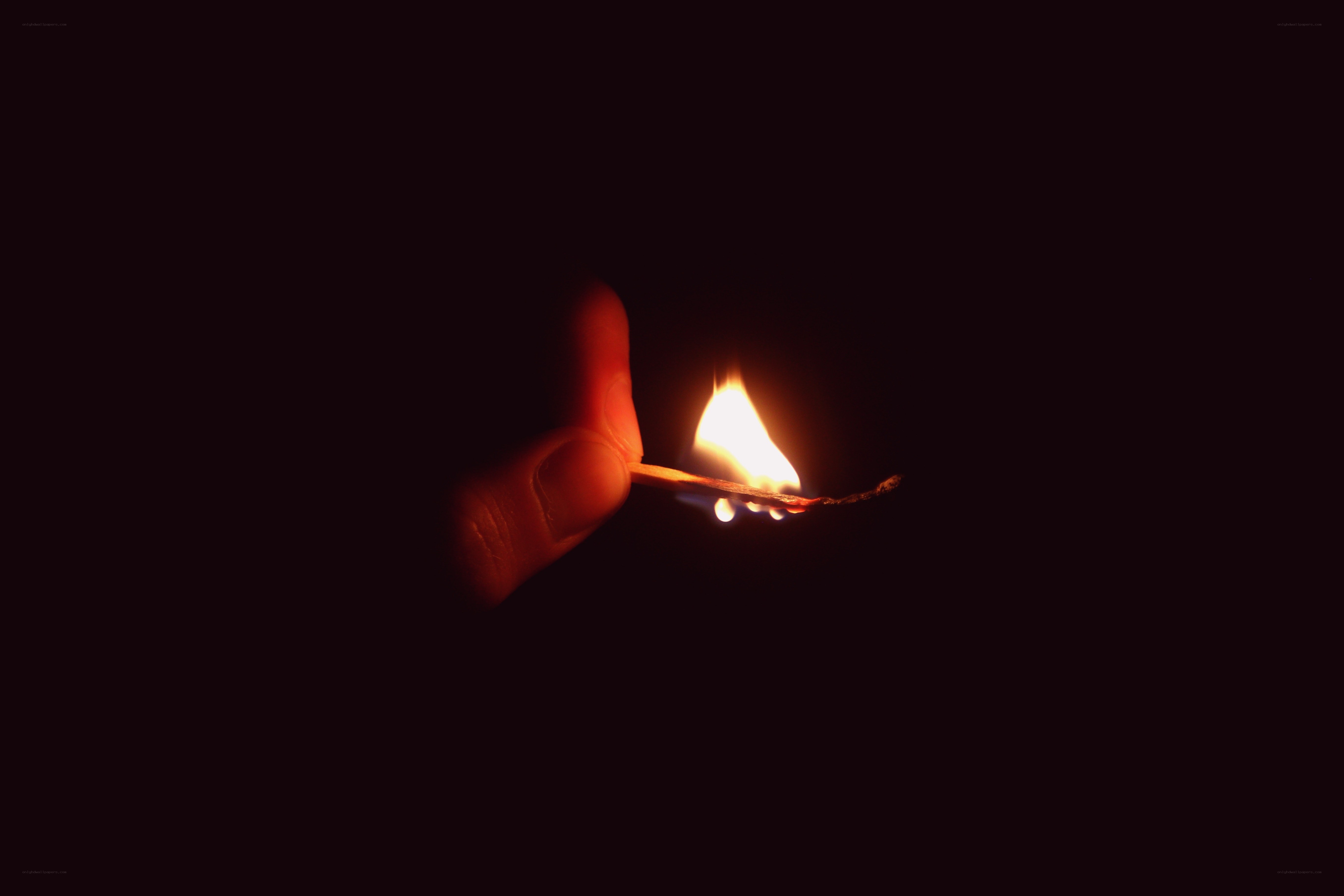 hand holding a lit match