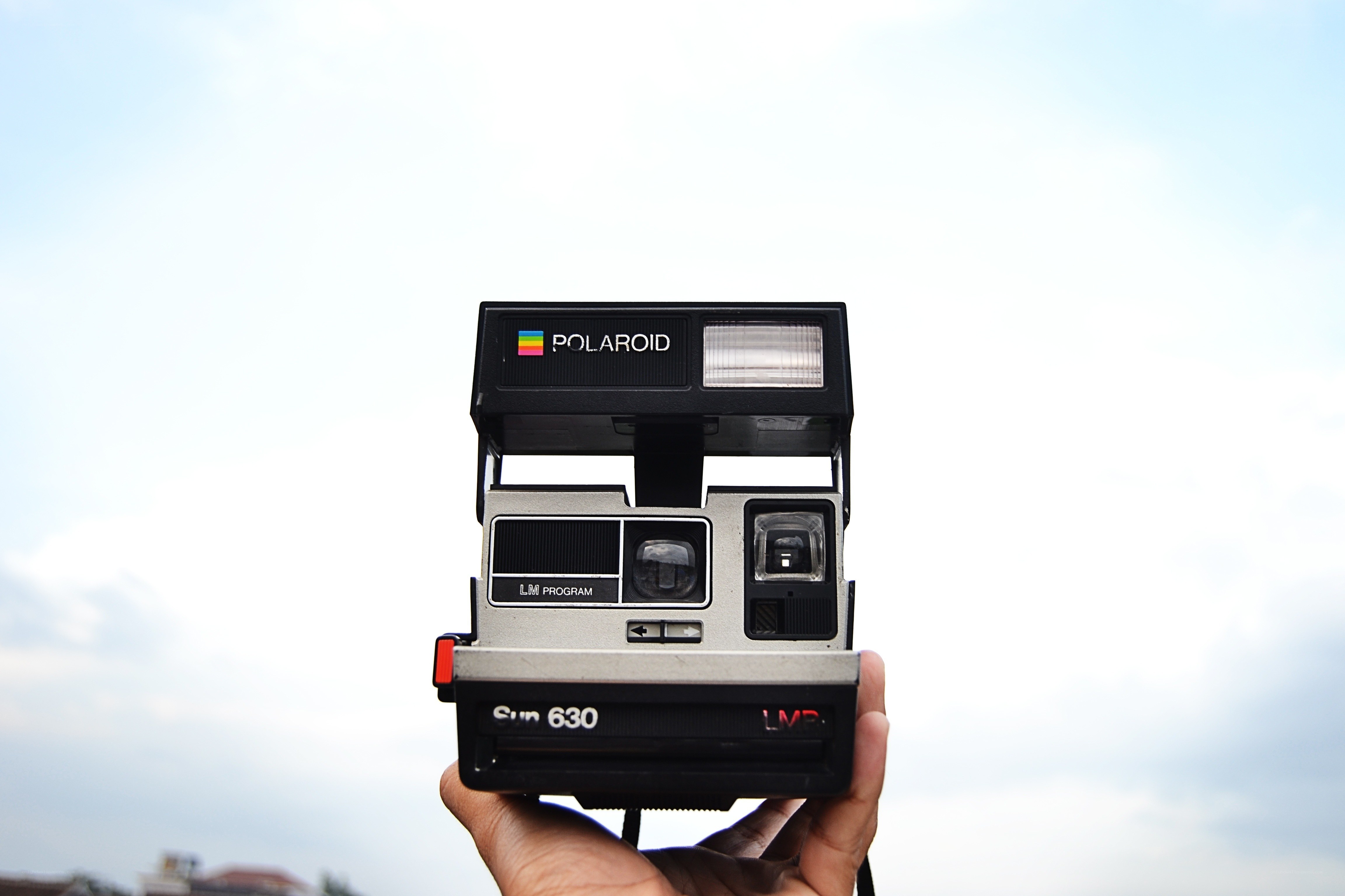 Hand holding a Polaroid camera