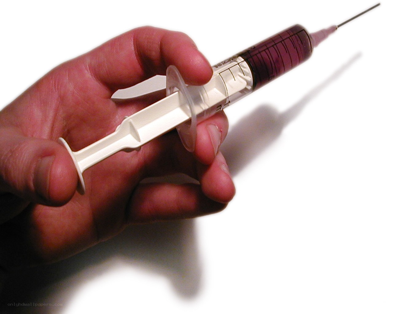 Hand holding a syringe