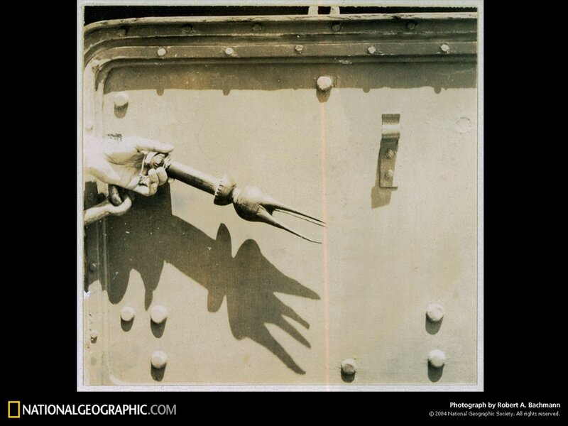 hand holding a tool on metal door