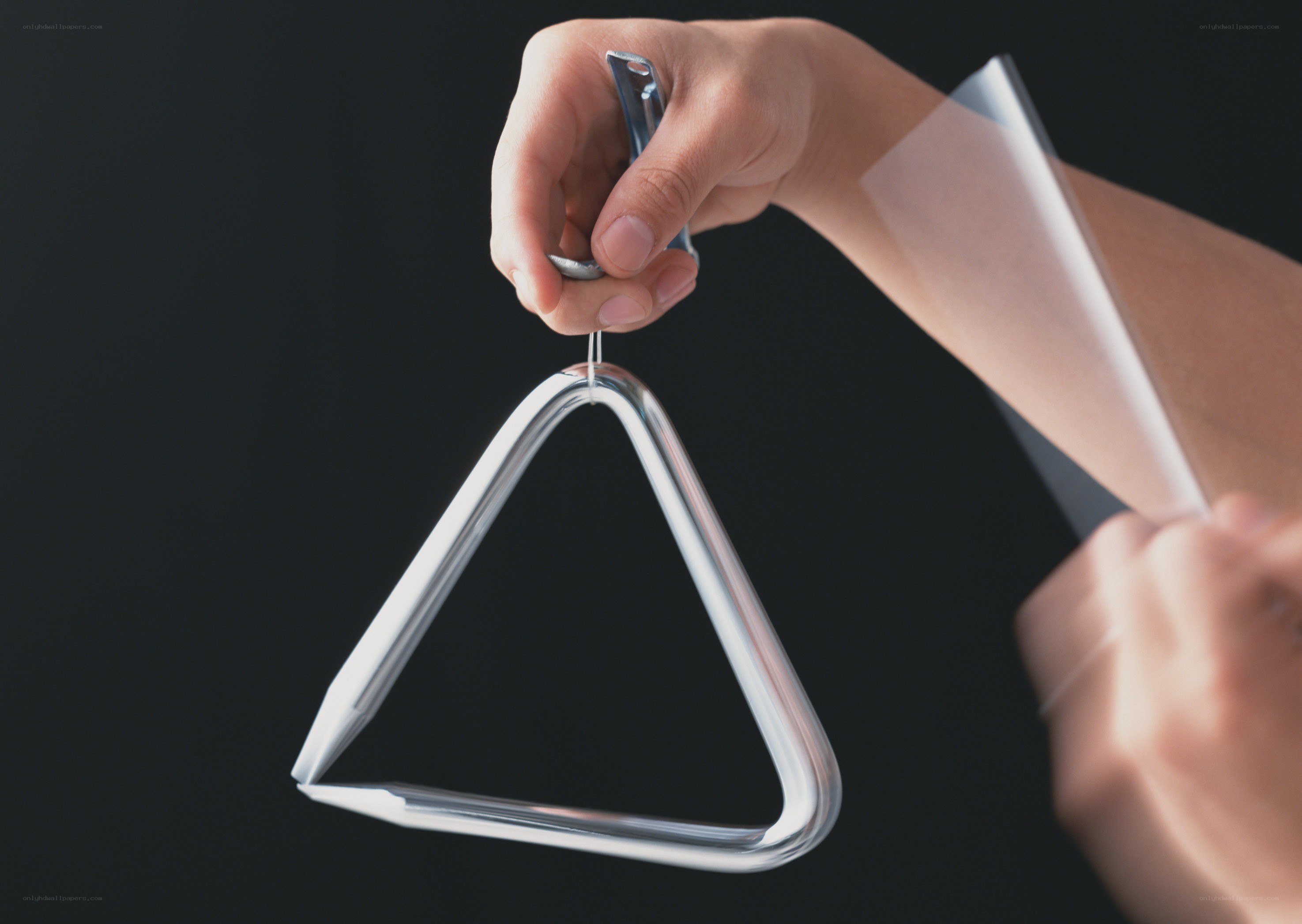 Hand holding a triangle percussion instrument
