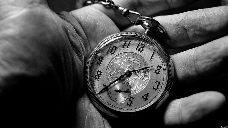Hand holding a vintage pocket watch