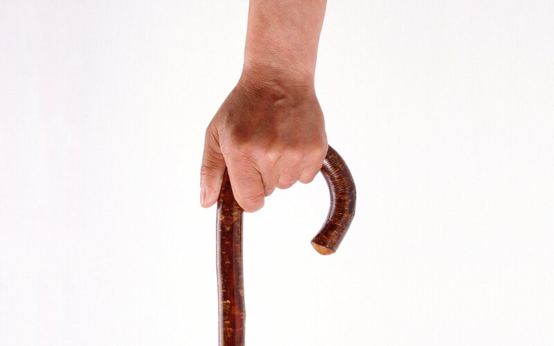 hand holding a wooden cane