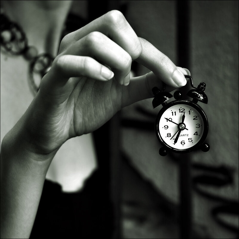 hand holding alarm clock