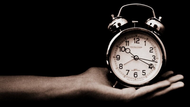 Hand Holding Alarm Clock — Black