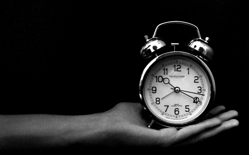 hand holding an alarm clock