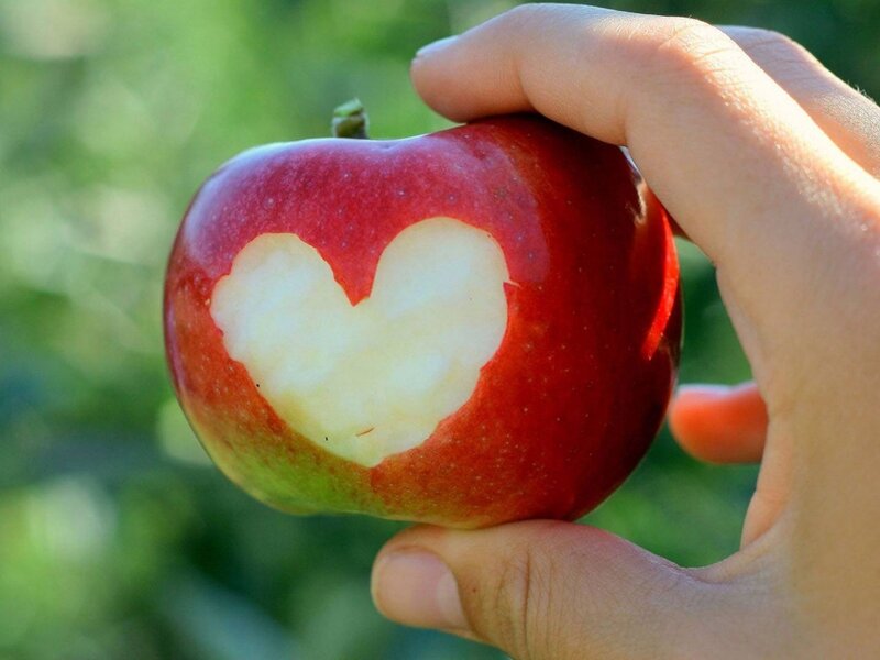 hand holding apple with heart shape
