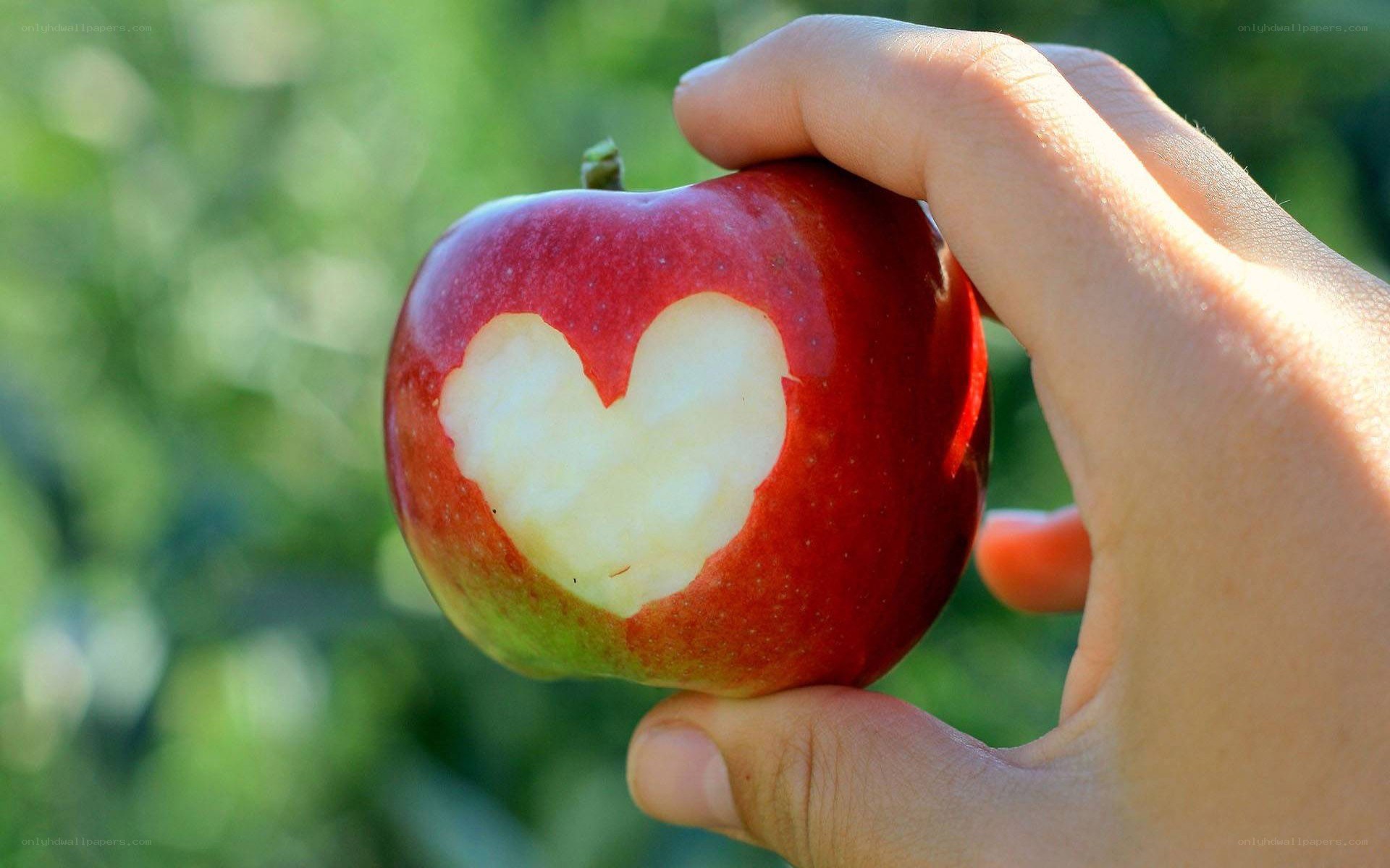 hand holding apple with heart