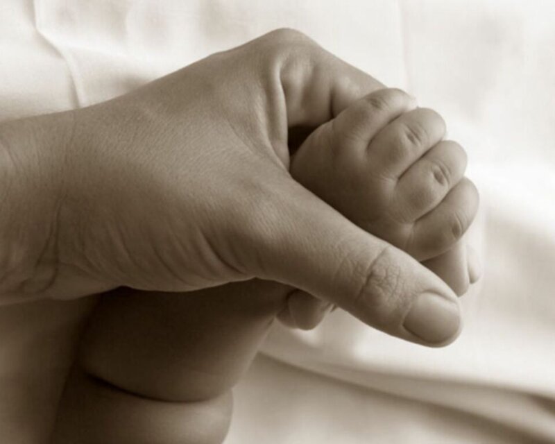 Hand holding baby's foot