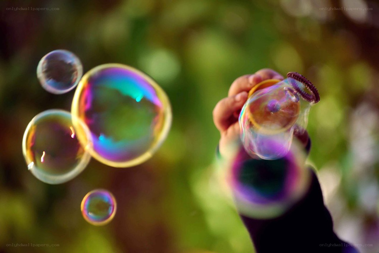 Hand holding bubble wand with bubbles