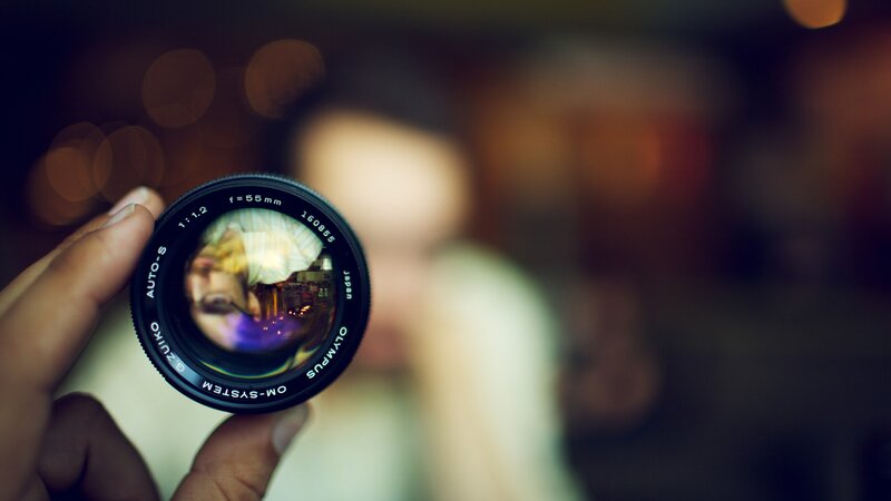 Hand Holding Camera Lens — Black