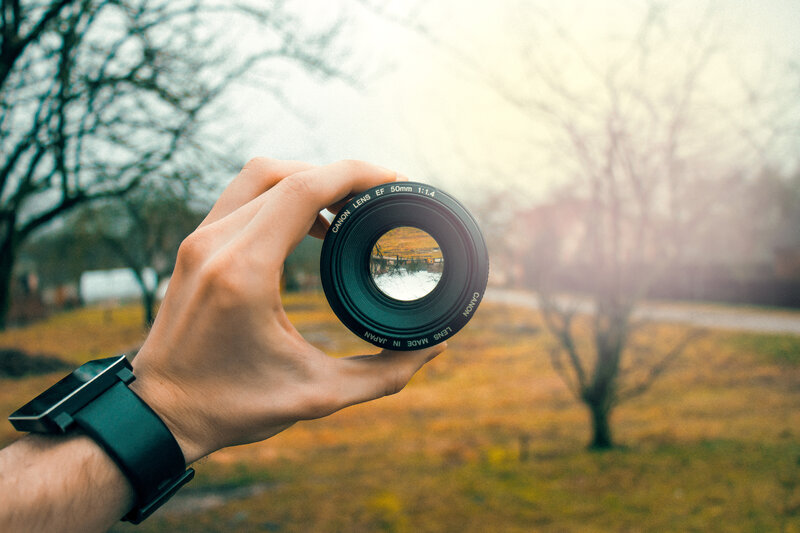 Hand Holding Camera Lens — Green