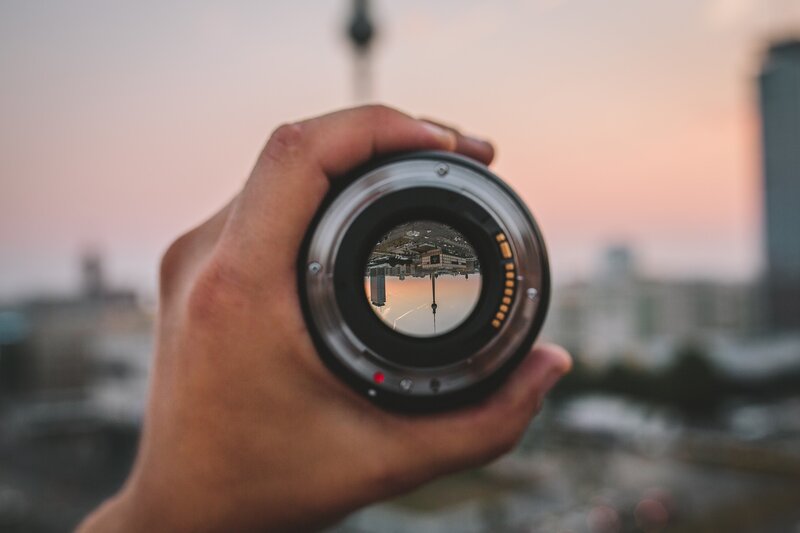 Hand Holding Camera Lens — Pink