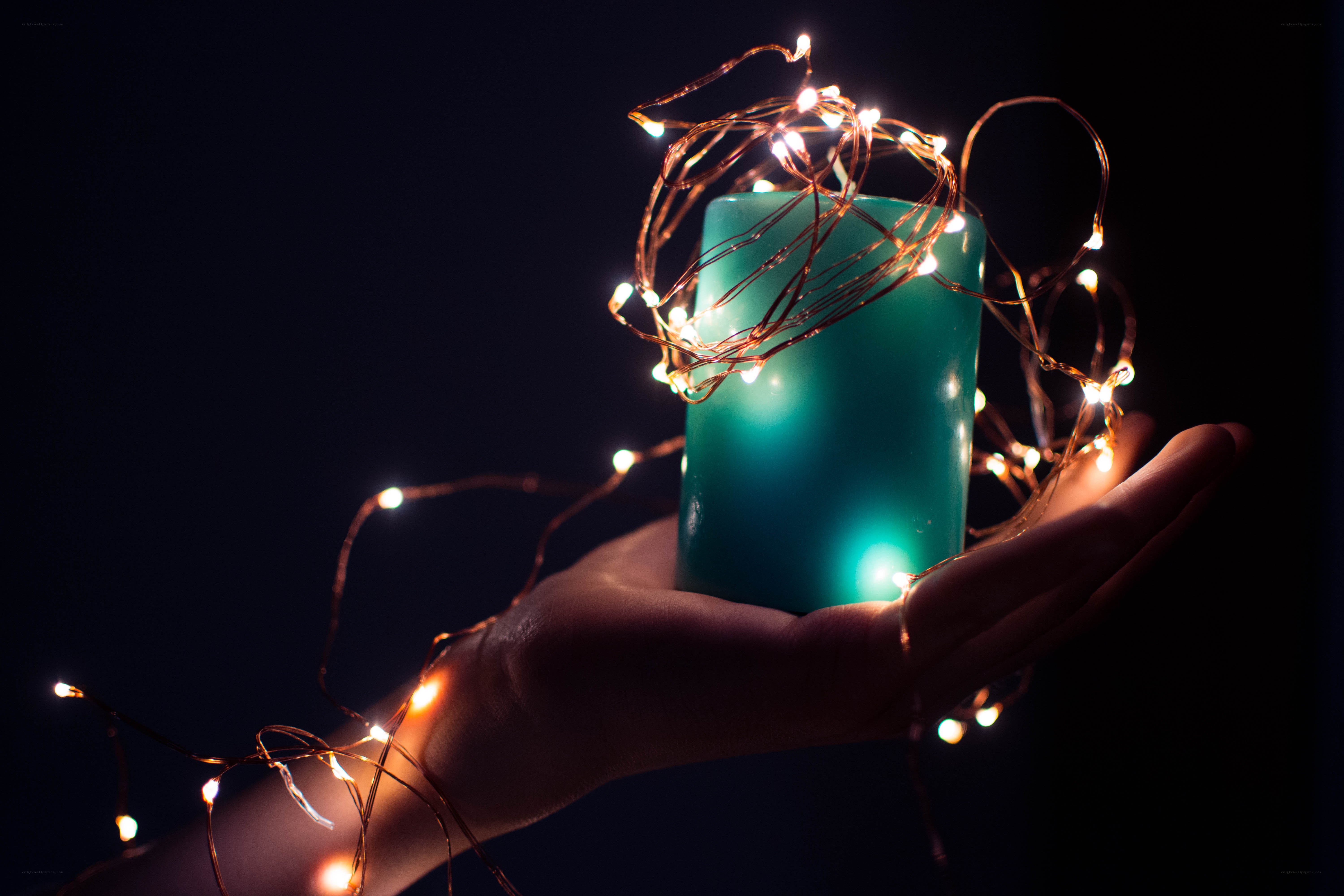 hand holding candle with lights