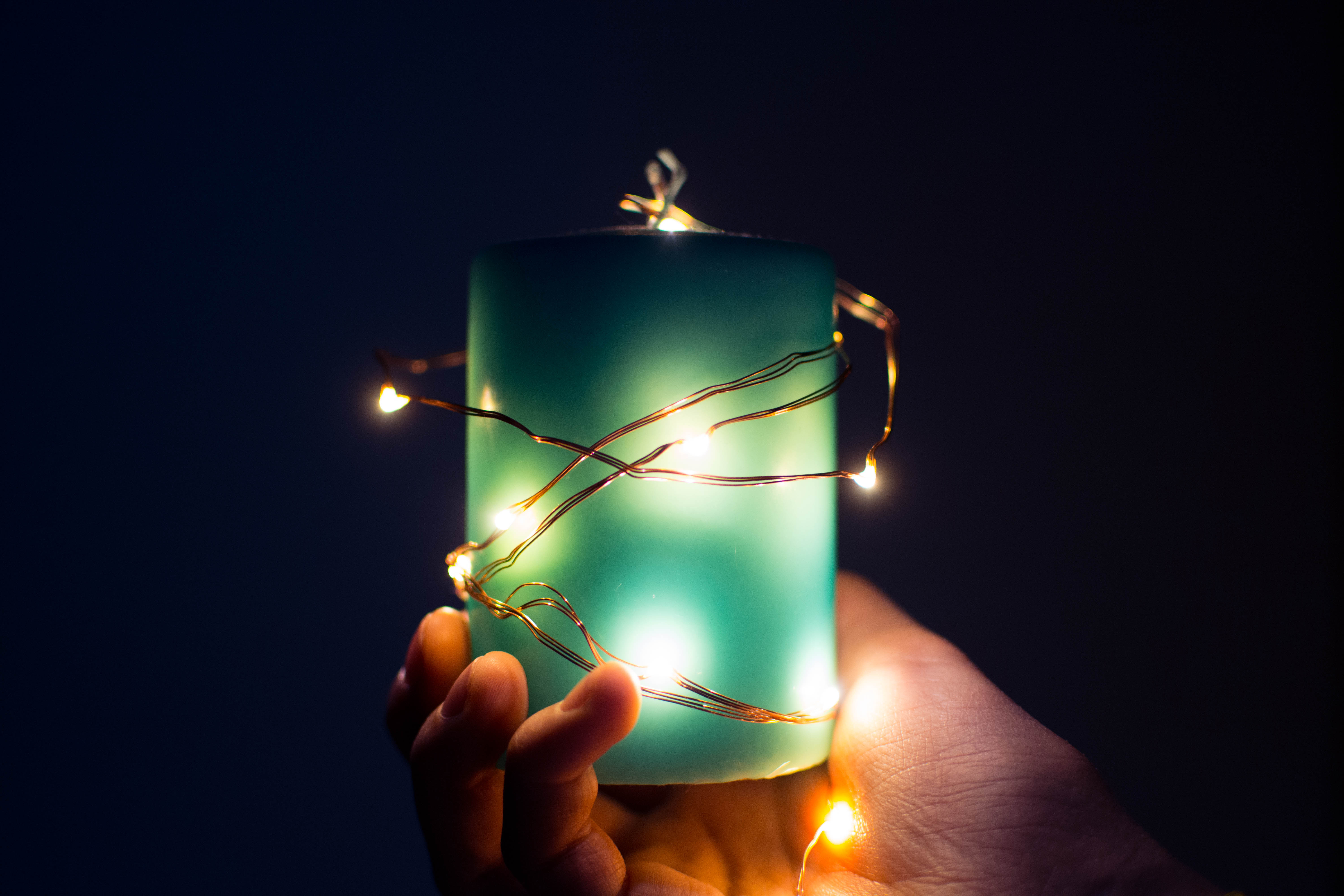 hand holding candle with lights