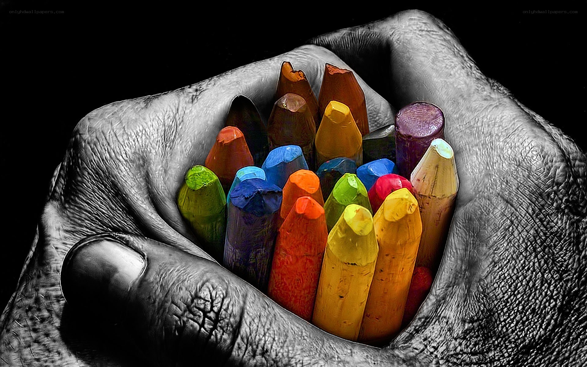 Hand holding colorful crayons