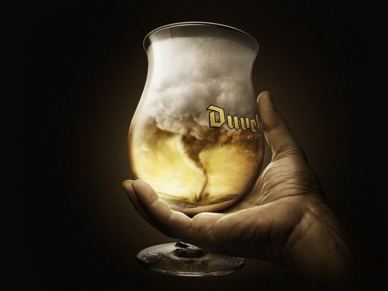 Hand holding Duvel beer glass