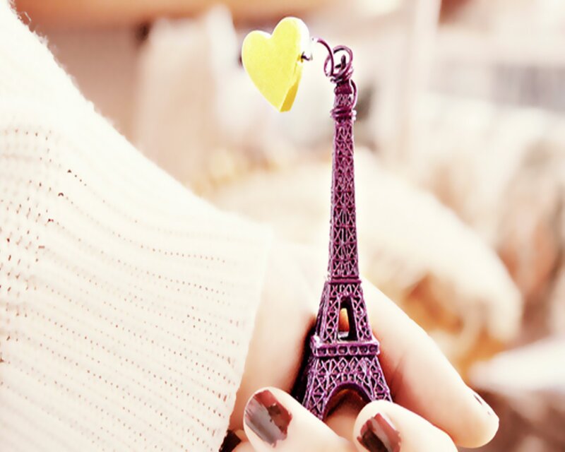 Hand holding Eiffel Tower charm