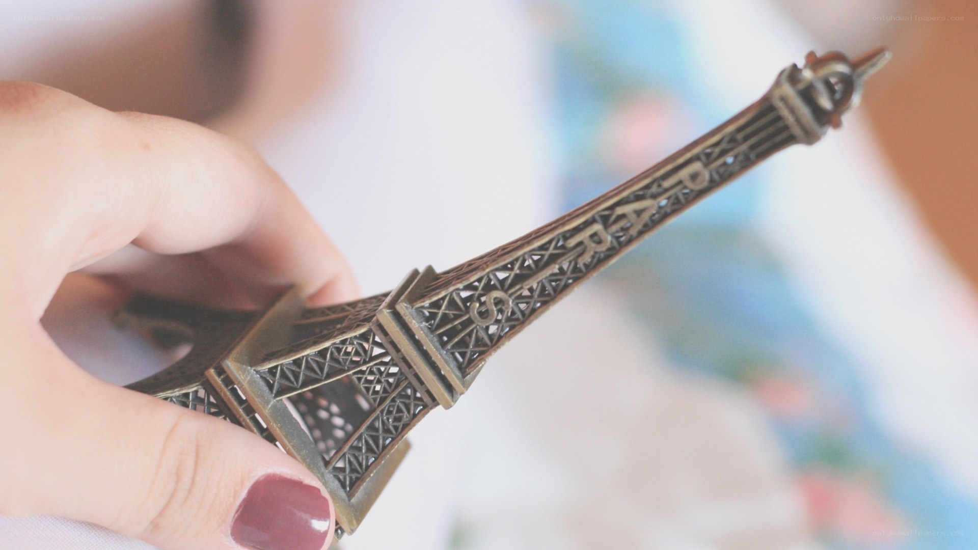 hand holding eiffel tower model